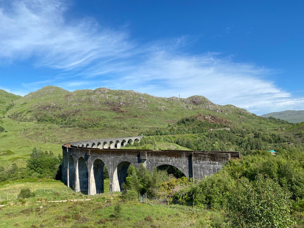 Glenfinnan Viaduct bridge in hills with blue sky, Scotland